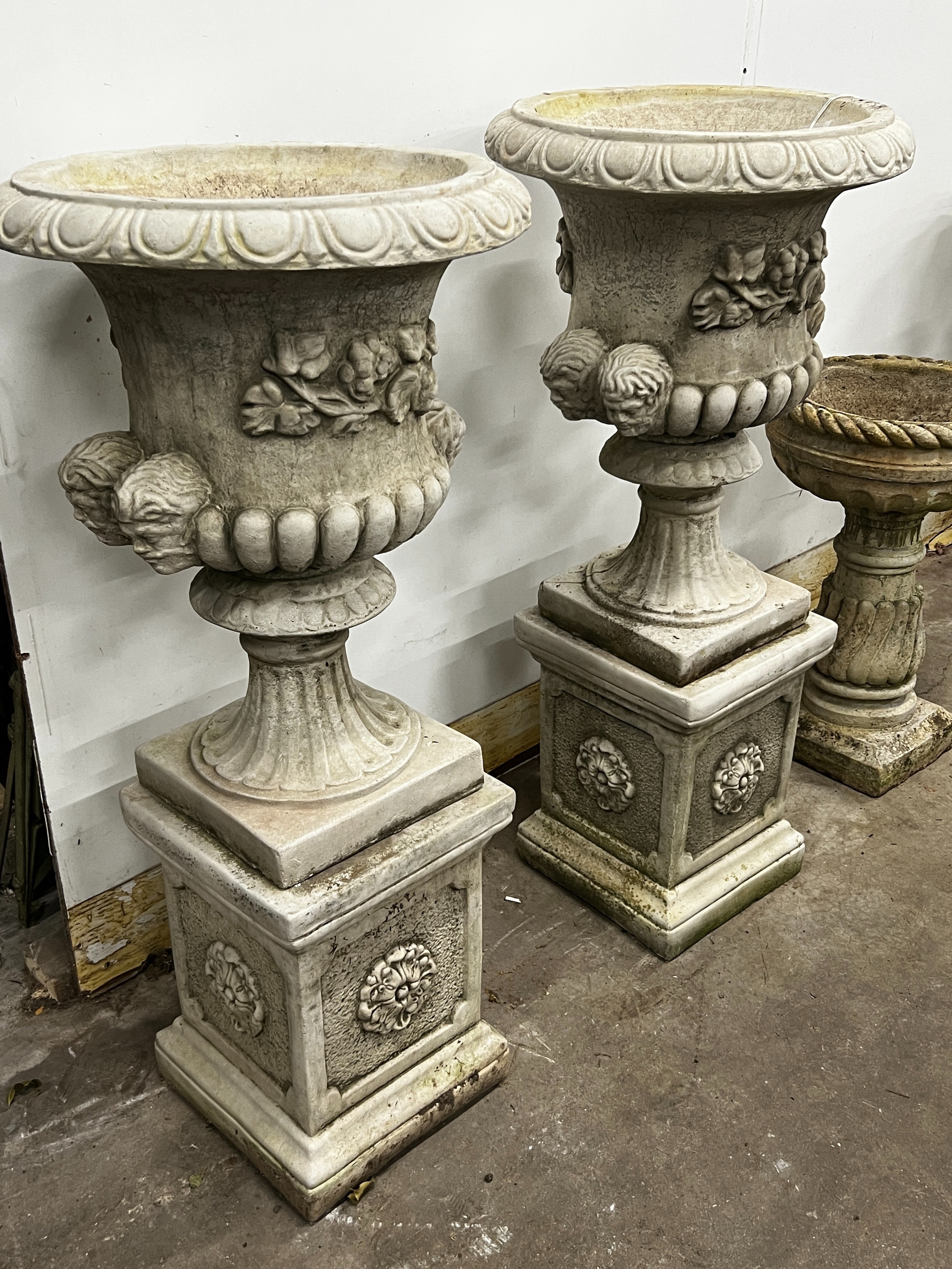 A pair of reconstituted stone campana garden urns on square pedestals, diameter 49cm, height 108cm